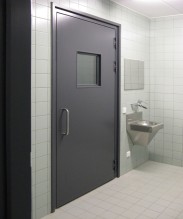 Огнеупорная дверь серого цвета с выпадающим порогом и окном